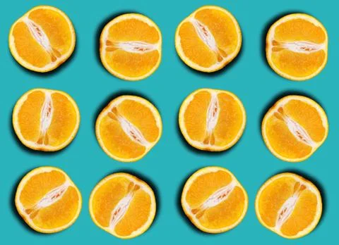 Pattern of fresh orange halves on a blue background. Stock Photos