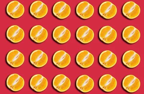 Pattern of fresh orange halves on a red background with a shadow. Stock Photos