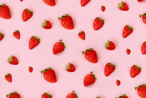 Pattern of fresh red strawberry on pink background, top view. Scattered berries Stock Photos