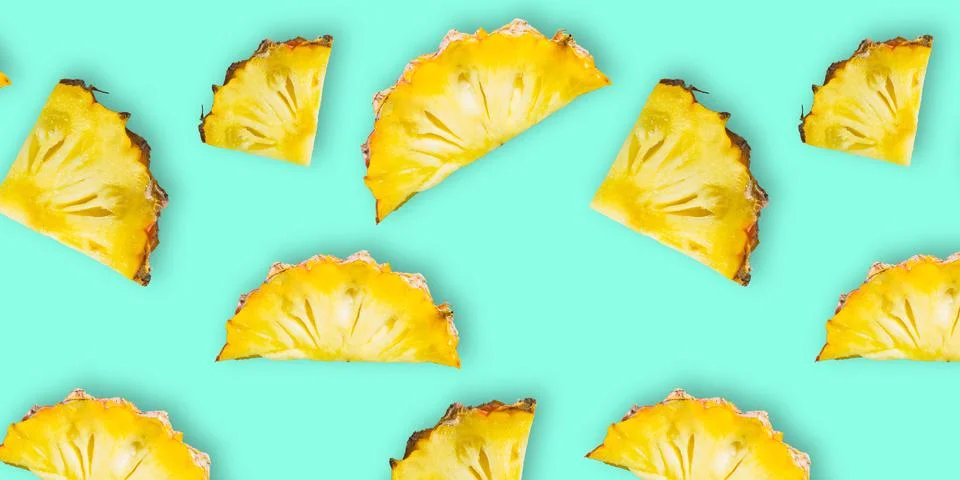 Pattern of fresh ripe pineapple slices isolated on cyan background. Top view Stock Photos