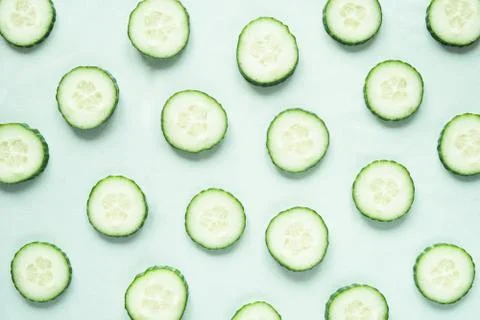 Pattern with freshly cut cucumber slices on green background Stock Photos