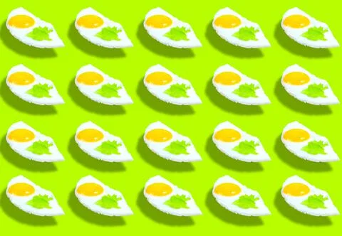 A pattern of fried eggs with lettuce leaves on a green background. Product sp Stock-Fotos