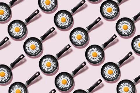 Pattern of fried eggs on pan on pink. Creative Scrambled Eggs Stock Photos