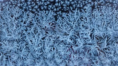 Pattern on frozen glass. unusual pattern on frozen glass. crystals of snow an Stock Photos
