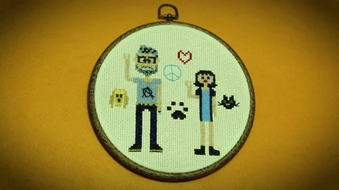 The pattern of  funny couple appears knitted in cross stitch. Stock Footage 139657152