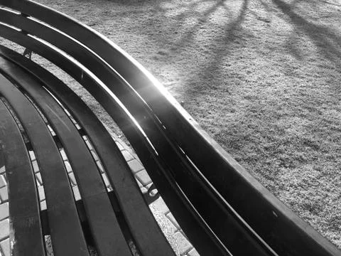 Pattern of geometric shapes on a street bench of wood on the lawn black and w 스톡 사진