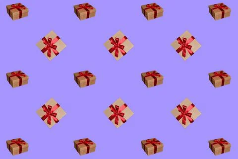 A pattern of gift boxes with a bow made with ribbon isolated on a purple back Stock-Fotos