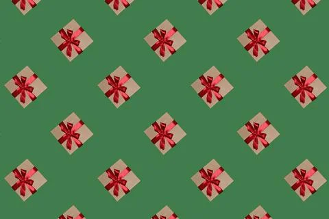 A pattern of gift boxes with a bow made with ribbon isolated on a green backg Foto stock