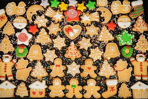 Pattern of gingerbread cookies in different shapes on a dark surface. Top view. Stock Photos