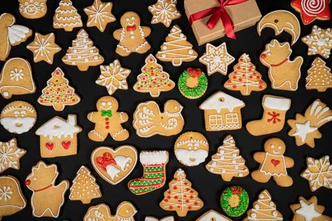Pattern of gingerbread cookies in different shapes on a dark surface. Top view. Stock Photos