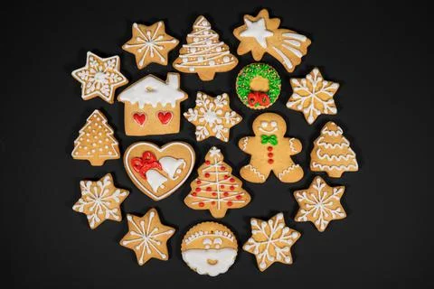 Pattern of gingerbread cookies in different shapes on a dark surface. Top view. Stock Photos