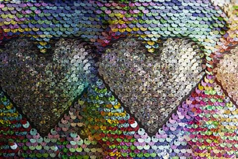 A pattern of glittering colored sequins form a heart shape Stock Photos
