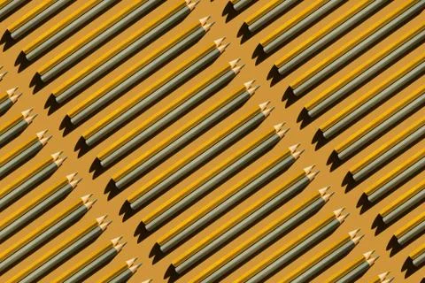 Pattern of gold and silver pencils on gold background. Stock Photos