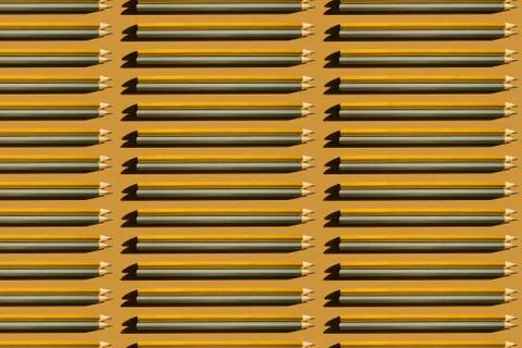 Pattern of gold and silver pencils on gold background. Stock Photos