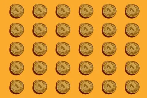 Pattern of gold medals on a yellow background. Stock Photos