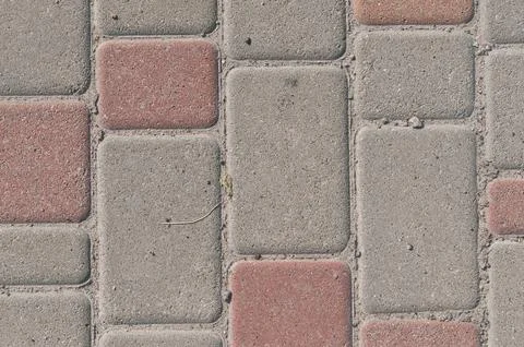 Pattern of gray and red paving stones on a sidewalk Stock Photos