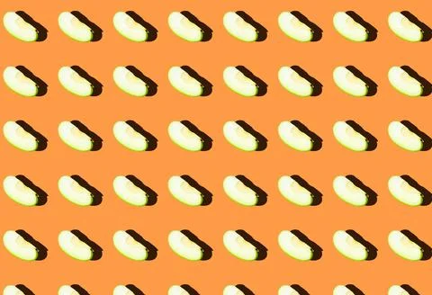 A pattern with green apple slices on an orange background. Stock Photos