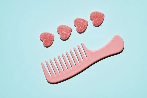 Pattern of gummy vitamin candy in shape of heart on blue background. Concept. Stock Photos