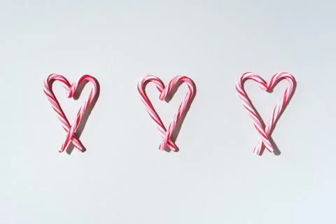 Pattern with hearts made of Christmas candy canes on grey background. Top view Stock Photos