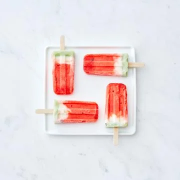 Pattern of ice cream on a stick in the shape of a square on a white plate on a Foto stock