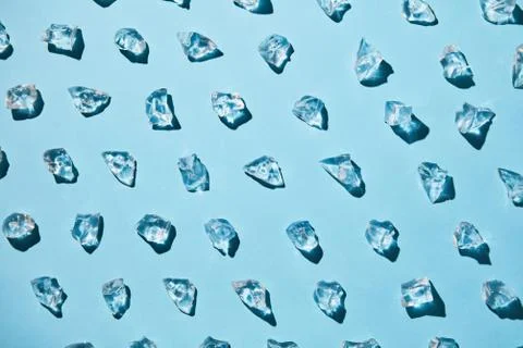 Pattern of ice cubes on a blue paper background. Refreshing background. Flat lay Stock Photos