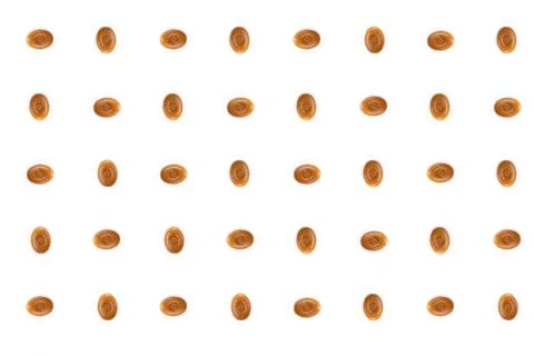 A pattern of interlacing oval caramel candies on a white background. Stock Photos