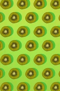 Pattern of kiwi. Top view of the sliced kiwi on green background. Minimal flat Stock Photos
