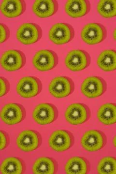 Pattern of kiwi. Top view of the sliced kiwi on pink background. Minimal flat Stock Photos