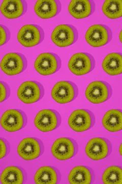 Pattern of kiwi. Top view of the sliced kiwi on pink background. Minimal flat Stock Photos