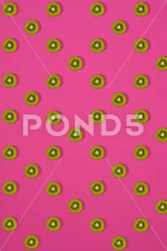Pattern of kiwi. Top view of the sliced kiwi on pink background. Minimal flat Stock Photos