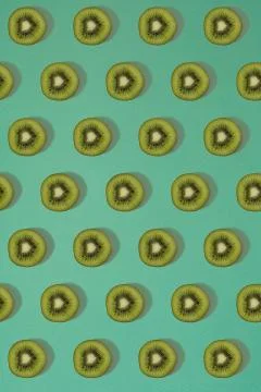 Pattern of kiwi. Top view of the sliced kiwi on blue background. Minimal flat Stock Photos