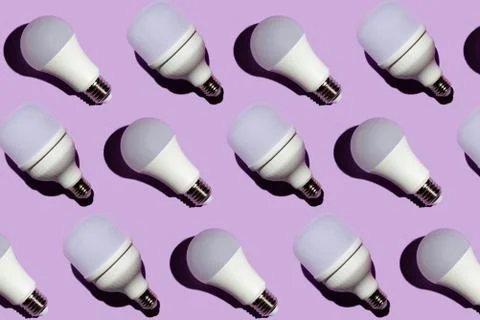 Pattern of led light bulbs with hard shadows on a purple background Stock Photos