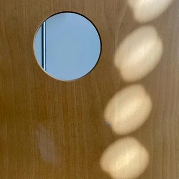 Pattern of light dots on curved wooden surface with hole top right Foto stock