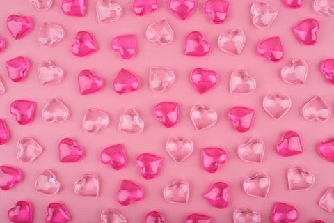 Pattern with light pink and dark pink glass glossy hearts on pink background. Stock Photos