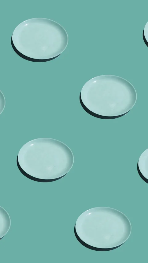 Pattern with lonely fried eggs and many empty plates animated on mint background Stock Footage 318511042