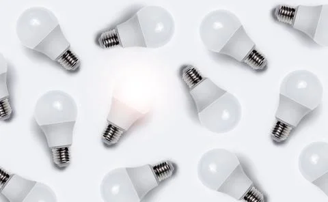 Pattern of luminous bulb between other with no lights bulbs. Creative idea. Stock Photos