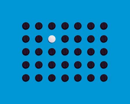 The pattern is made of black pharmaceutical tablets on a blue background. One Stock Photos