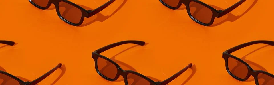 Pattern made with black plastic 3d glasses on orange background Stock Photos
