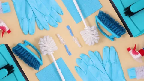 Pattern made of blue house cleaning tools move on beige background. Stop motion Stock Footage 151555775