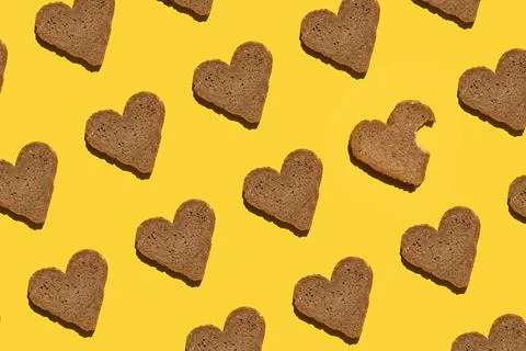 Pattern made with bread in heart form on yellow background, as backdrop or te Foto stock