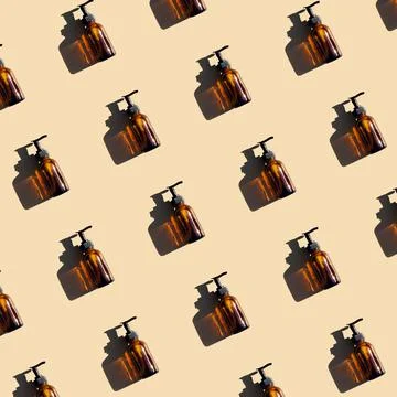 Pattern made with brown glass bottle with pump of cosmetic products and stron Stock Photos