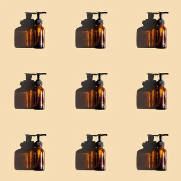 Pattern made with brown glass bottle with pump of cosmetic products and stron Stock Photos