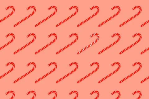Pattern made from Christmas candy canes isolated on coral. Stock Photos