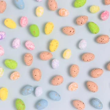 Pattern made of colorful easter eggs on a blue pastel background. Stock Photos