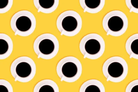 Pattern made of cup with black coffee on a yellow background. Stock Photos