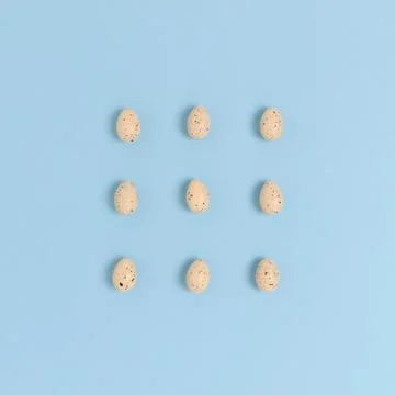 Pattern made of easter eggs on a blue pastel background. Stock Photos