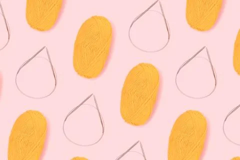 Pattern made of knitting needles and skein of yellow wool thread. 스톡 사진