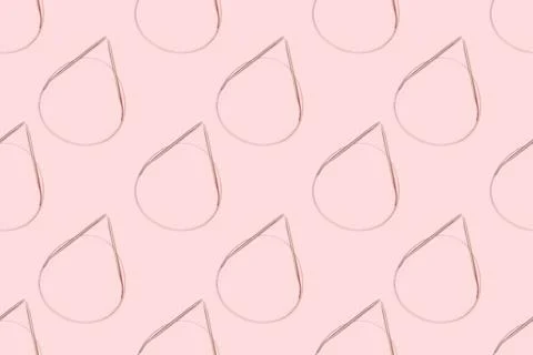 Pattern made of knitting needles on a pink background. Stock Photos