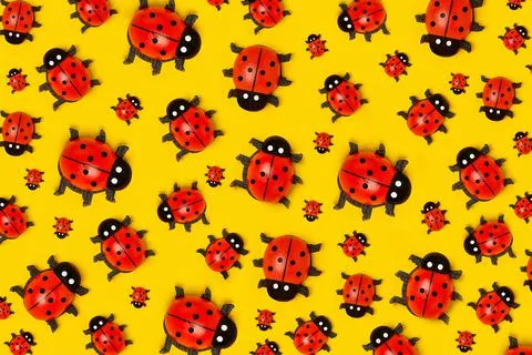 Pattern made with ladybugs on yellow background, as backdrop or texture. Brig Stock Photos