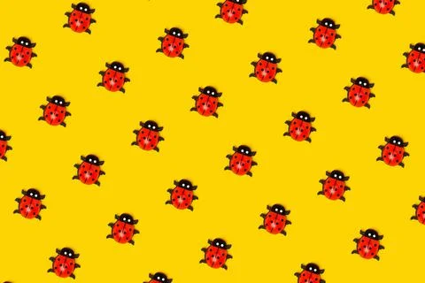 Pattern made with ladybugs on yellow background, as backdrop or texture. Brig Foto stock